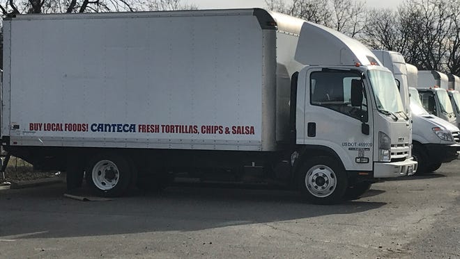 Trucks that distributed product for Canteca Foods sit in the parking lot of the building the company once leased space in.