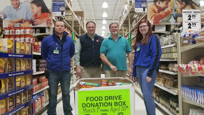 Manager Brian Magyar, Salvation Army Director of Social Services Ron Jacobson and Food Pantry Coordinator Kurt Schuller and Menards Associate Savanna Baker stand in the grocery aisles in Menards.