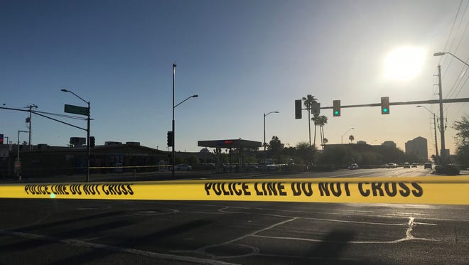 Police tape blocked off the street where officers were involved in a shooting April 14, 2018, near 13th Avenue and Thomas Road in Phoenix.