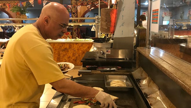 Tabooleh Mediterranean Buffet co-owner Yasser Gaber is shown cooking mushroom and vegetables at his restaurant in Coralville on May 11, 2018.