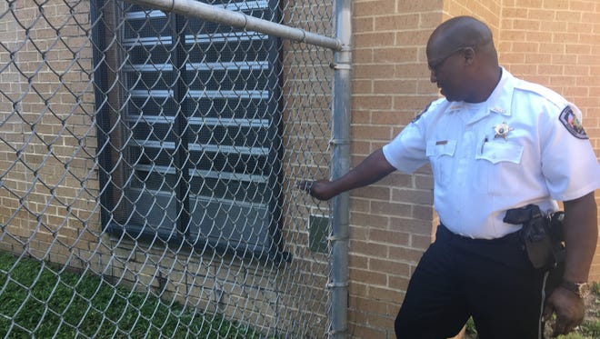 Autauga Metro Jail Warden Larry Nixon shows where people allegedly passed contraband through the jail fence, near the female inmate exercise yard.