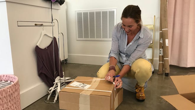 MOVE Boutique co-owner Raena Rasmussen unboxes merchandise. MOVE opened Monday and will sell dance and athleisure apparel.