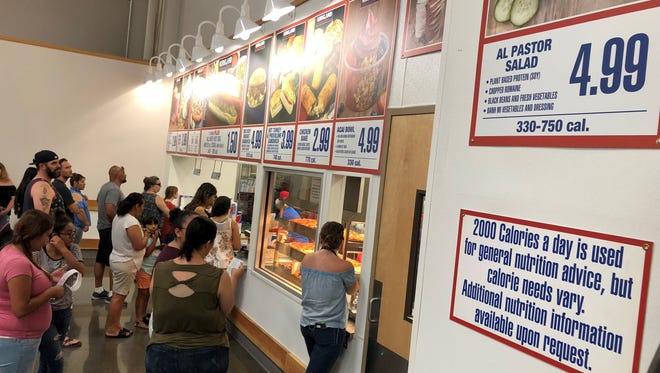 Customers order food at Costco Wholesale in Visalia.