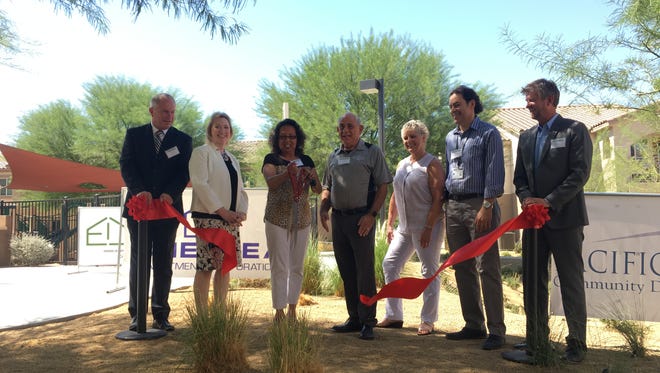 Judy Twilley, the USDA's rural development loan specialist in charge of the agency's involvement in the Cesar Chavez Villas project cuts the ceremonial ribbon at the official opening ceremony of the project's second phase.