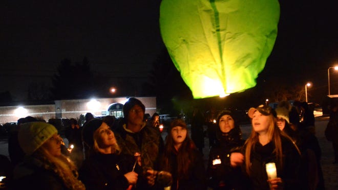 A Chinese lantern is released during a candlelight vigil for David and Jackson Lyons in Highland Township.