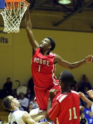 MOLLY BARTELS / COURIER &amp; PRESS Bosse's JaQuan Lyle grabs the rim as he dunks against Memorial during a game at Memorial High School in 2012.