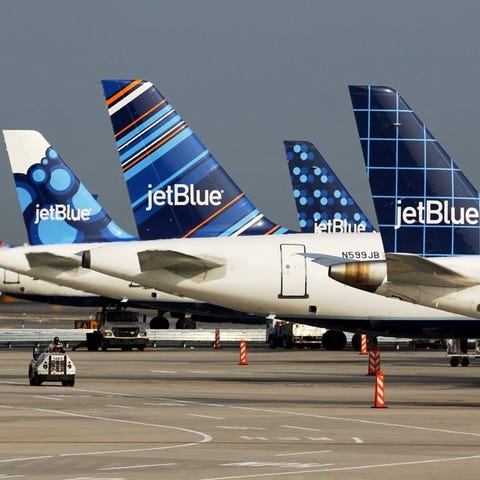 A line of JetBlue tails parked at the airport.