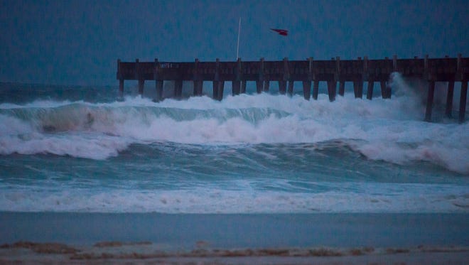 The surf pounds the pier and shore as Hurricane Nate approaches in Pensacola Beach during twilight on Saturday, October 7, 2017.