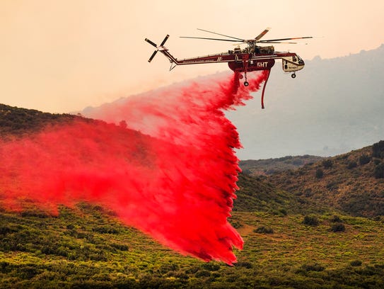 A helicopter drops retardant near the Goodwin Fire