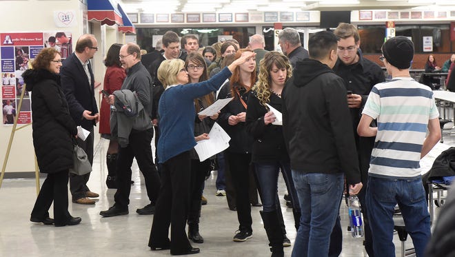 Voters stand in line Tuesday during the Senate District 14 Republican Caucus at Apollo High School in St. Cloud. 