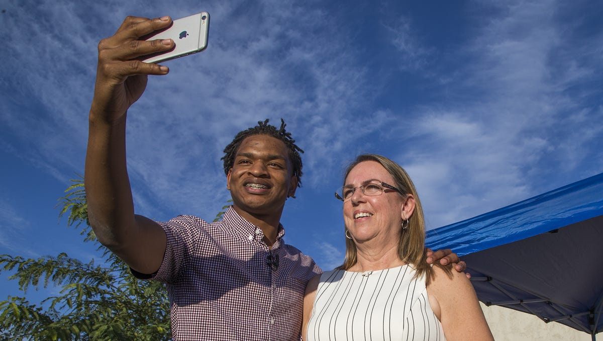 Jamal Hinton and Wanda Dench take a selfie together after meeting at Wanda's home for Thanksgiving dinner, in Mesa, Ariz.  Dench, who accidentally texted Hinton, a stranger, an invitation to Thanksgiving dinner made good on her offer, greeting the teen visitor with a hug and an oven full of food after their story swept through social media.