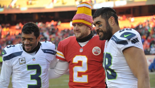 Seattle quarterback Russell Wilson (left), Kansas City punter Dustin Colquitt and tight end Tony Moeaki pose for a photo after a November game at Arrowhead Stadium. Moeaki, a one-time Iowa star at tight end, formerly played for the Chiefs and is now a member of the NFC champion Seahawks.