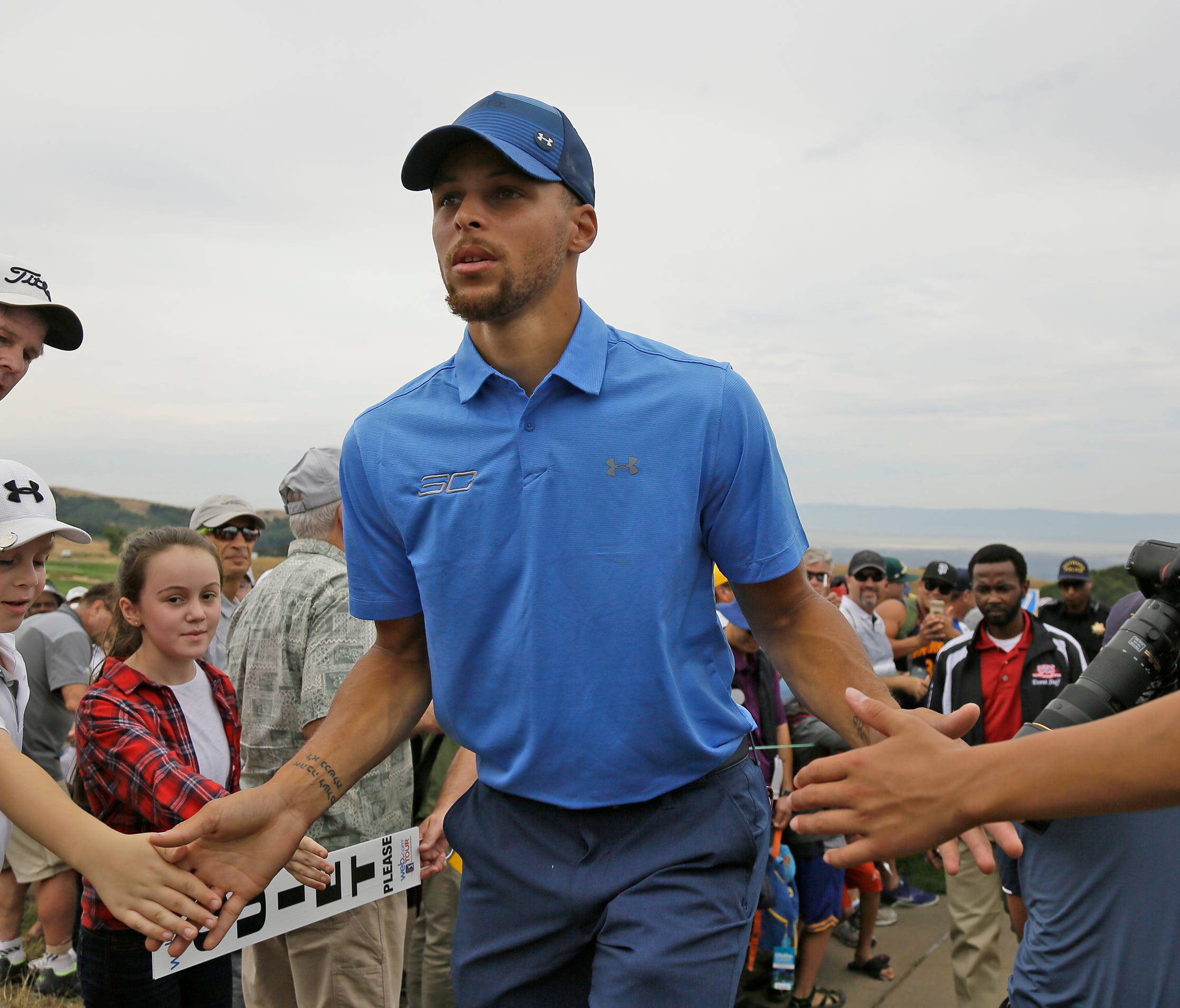 Golden State Warriors NBA basketball player Stephen Curry makes his way past the gallery to the 18th tee during the Web.com Tour's Ellie Mae Classic golf tournament  on Thursday.