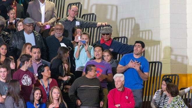 Phoenix resident Jose Patino (right, with hands crossed) said he didn’t plan to interrupt President Barack Obama’s speech at Del Sol High School in Las Vegas on Friday. “He needs to hear not everything is all right. … I know it’s going to stick with him,” Patino said.