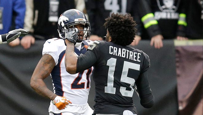 Denver Broncos cornerback Aqib Talib (21) fights Oakland Raiders wide receiver Michael Crabtree (15) during the first half of an NFL football game in Oakland, Calif., Sunday, Nov. 26, 2017.