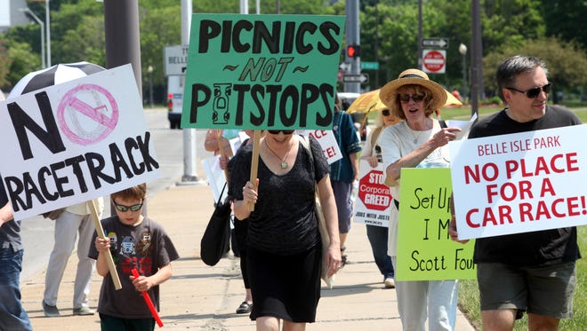 Several members of the group "Belle Isle Concerned" walk on the median on Jefferson Avenue in Detroit, Michigan on Saturday, May 28, 2016 at the entrance to Belle Isle to protest next weekends Detroit Grand Prix.