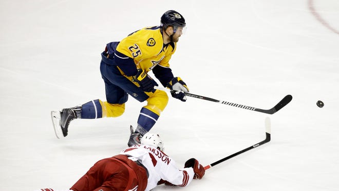 Arizona Coyotes defenseman Oliver Ekman-Larsson, bottom, of Sweden, dives for the puck as Nashville Predators left wing Viktor Stalberg (25), of Sweden, moves it down the ice in the first period of an NHL hockey game Tuesday, Oct. 21, 2014, in Nashville, Tenn.