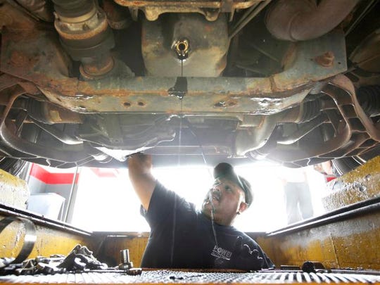 Dennis Aikey of Naples changes the oil on an SUV at Power Automotive in Canandaigua in this file photo. New York Gov. Andrew Cuomo has suspended the state's annual inspection requirement during the COVID-19 pandemic.