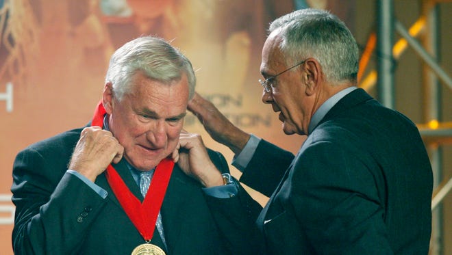Larry Brown, right, presents former North Carolina head basketball coach, Dean Smith, with a medal during Smith's induction into the National Collegiate Basketball Hall of Fame in Kansas City, Mo., in November 2006.