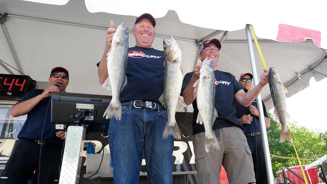 Ken Steffes and Lucas Schneider hold up four of their five fish that won them $13,000 in the Mercury Marine Walleye Weekend fishing tournament that concluded Sunday. The combined weight of their 10 fish caught was 34.4 pounds.