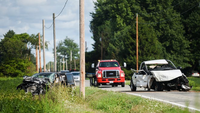 Two cars involved in a fatal crash Salem Road on Wednesday are towed from the accident scene after officers of Highway patrol inspected the wreckage.