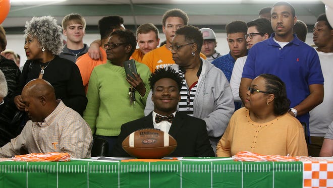 LaTrell Bumphus, center, smiles as family and friends gather to pose for a picture picture to help celebrate his commitment to the University of Tennessee in the field house at Hardin County High School in Savannah, Tenn., on Wednesday, Feb. 1, 2017.