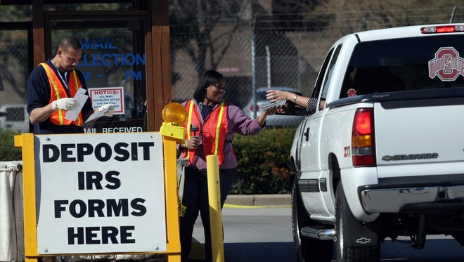 U.S. postal workers take mail from people dropping off their taxes on Tax Day in 2008. Ohio officials say that in 2014, instances of attempted tax fraud skyrocketed from $10 million a year to more than $265 million, prompting the state to launch new safeguards in 2015.