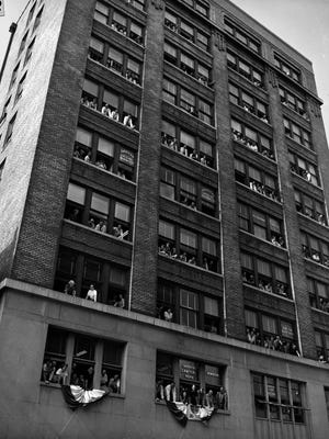 People leaning out of the Woodruff Building to greet President Harry S. Truman, ca. 1952