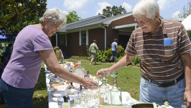 Rich and LaVonne Harp look at drinking glasses on Quiet Dale drive Thursday afternoon during the 12th Annual Highway 70 Yard Salet. The sale, which will be held until June 13, extends from Memphis to Nashville.