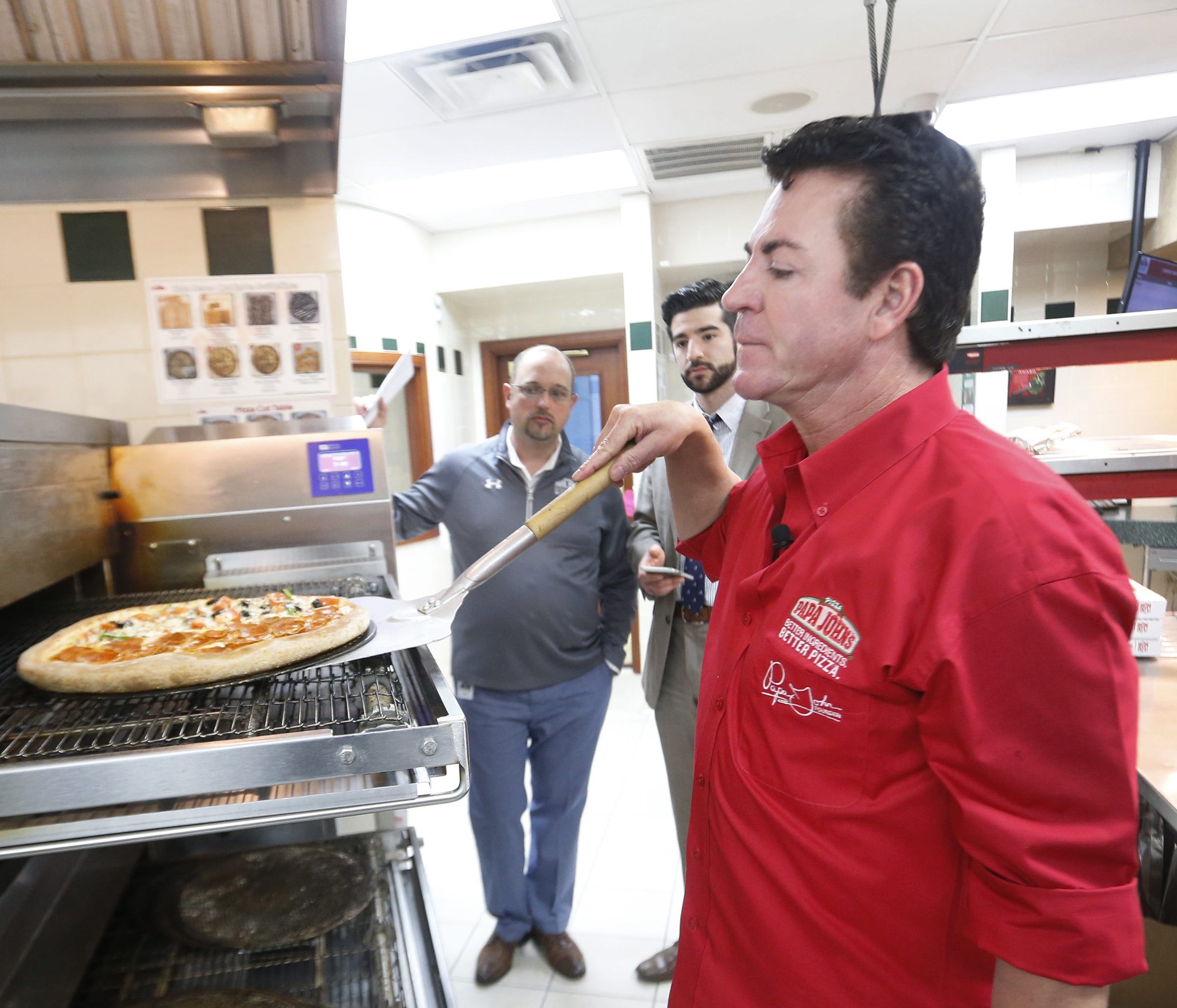 John Schnatter, of Papa John's Pizza places a pie in the oven in the kiitchen at the company's headquarters. By Pat McDonogh, The Courier-Journal. Jan. 26, 2016. [Via MerlinFTP Drop]