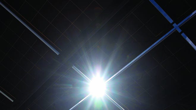 The sun shinesbetween solarpanels on March 12at the Aztec solarfarm.