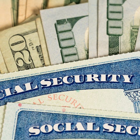 Two Social Security cards lying atop a fanned pile