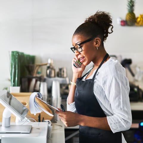 Woman looking at notepad while on phone