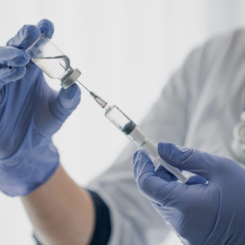 Healthcare professional holding a syringe with a n