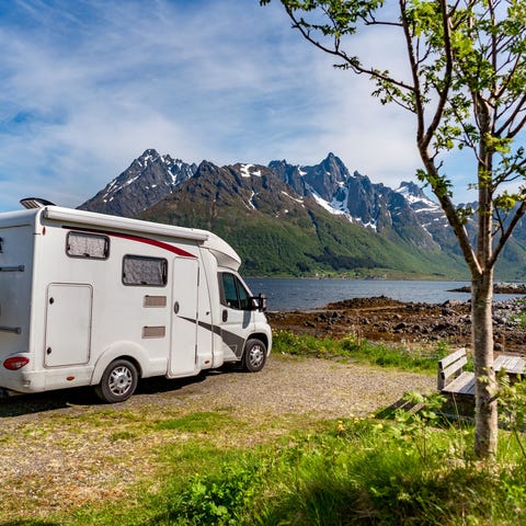 An RV parked near a scenic lake view.