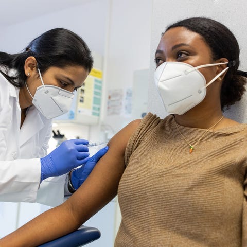 A medical worker is administering a vaccine to a p