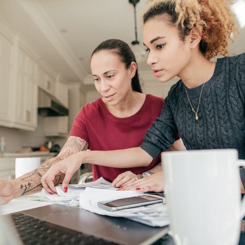 Two adults looking at a laptop and paperwork.