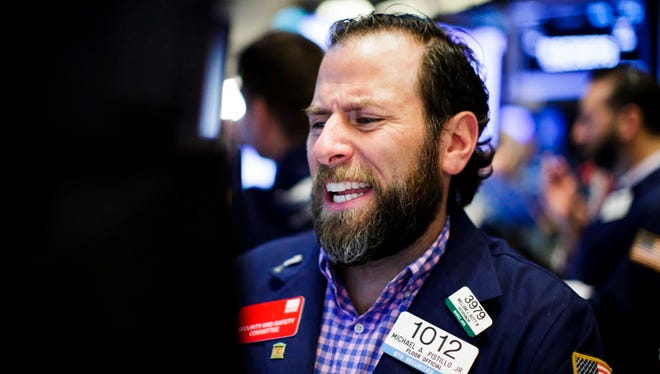 A trader reacts while working on the floor of the New York Stock Exchange (NYSE) at the start of the trading day in New York.