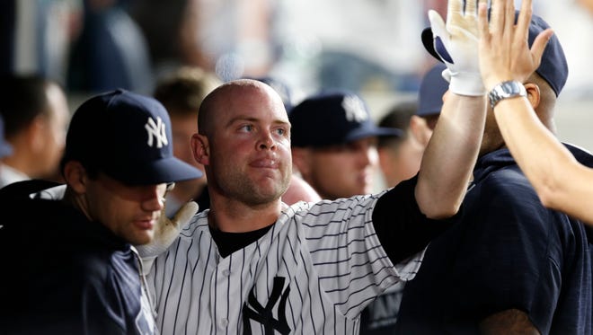 New York Yankees Brian McCann greets teammates in the dugout after hitting a solo home run during the seventh inning of a baseball game against the Los Angeles Angels at Yankee Stadium in New York, Monday, June 6, 2016.