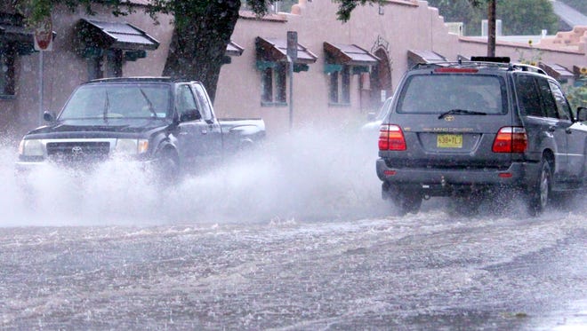 Vehicles had to drive through flooded streets on College Avenue in Silver City on Thursday evening.