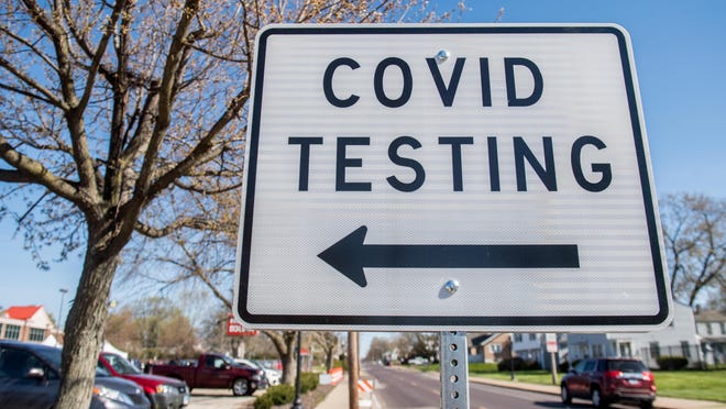 Signs direct vehicles into the Heartland Health Services parking lot for drive-through COVID-19 testing Tuesday, April 21, 2020 at 2321 N. Wisconsin Avenue in Peoria.