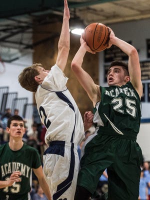 St. Johnsbury Academy's #25 Alex Carlisle gets off a shot over MMU's #2 Trent LaBounty during their boys basketball match up in Jericho Friday night, Jan. 27, 2017. Battling back from a deficit much of the game, St. J would pull ahead in the final seconds after a tie that forced over time. But MMU's LaBounty shut the door with a stunning three-point shot in the final seconds to win 58-56. 