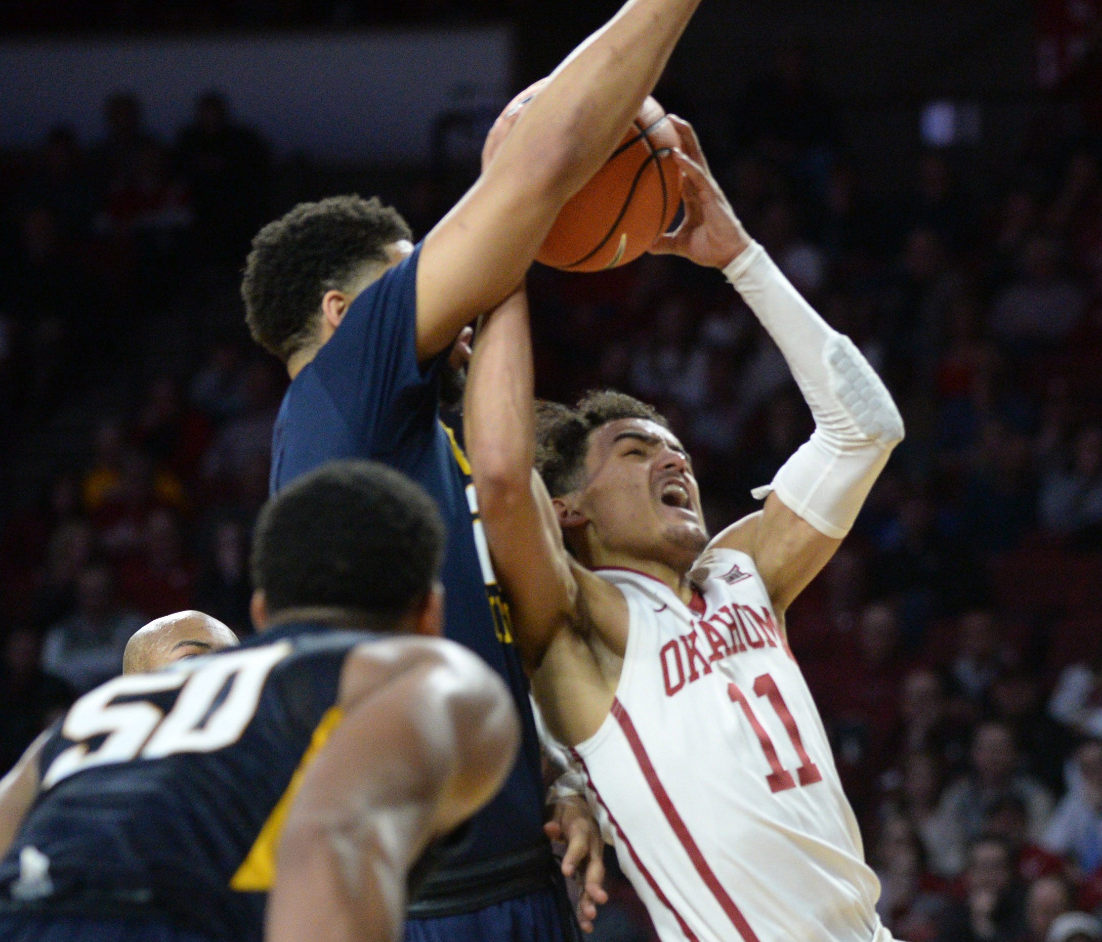 Oklahoma Sooners guard Trae Young (11) is fouled on a shot attempt by West Virginia Mountaineers forward Esa Ahmad (23) during the second half at Lloyd Noble Center.
