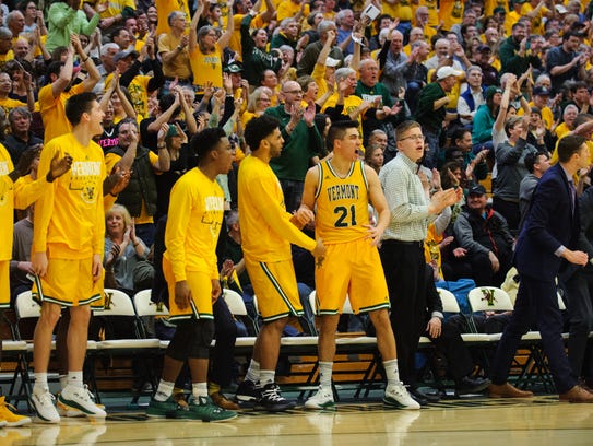 The Vermont bench celebrates during the America East