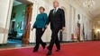 Trump and German Chancellor Angela Merkel walk down