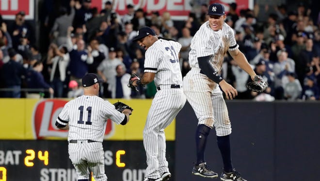 New York Yankees' Aaron Judge, right, celebrates with Aaron Hicks (31), center, as Brett Gardner, left, watches after the Yankees defeated the Minnesota Twins 8-4 in the American League wild-card baseball playoff game, early Wednesday, Oct. 4, 2017, in New York.