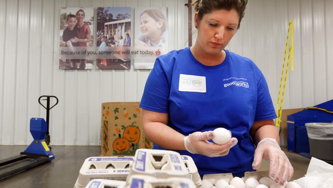 Brittany Rogers checks eggs to make sure they aren't broken while volunteering at Ozark Food Harvest on Friday December 18, 2015 with some of her coworkers from Chase.
