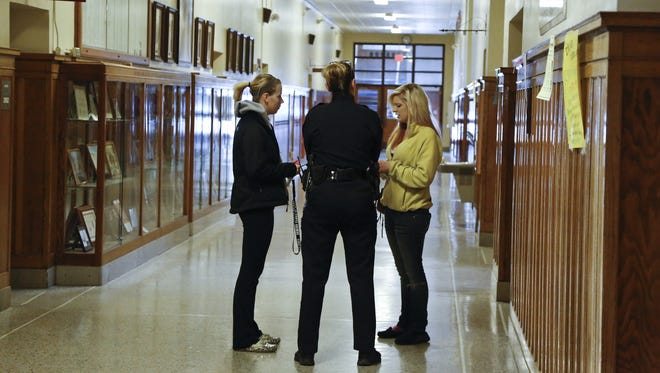 A school resource officer counsels students.