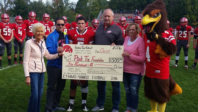 Before Saturday's game against Palmyra, Haddon Township's football program donates a $500 check to the Pink Tie Foundation in honor of Kate Pergola, who died in 2008 after a battle with breast cancer. From left: Kate's mother Diane Grady, Hawks' QB Club co-president John DiCrescenzo, team linebacker and Kate's son Wade Pergola, his father Scott Pergola, Tracey DiCrescenzo.