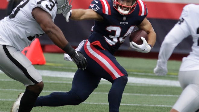 Patriots running back, Rex Burkhead, moves around Raiders defender Maurice Hurst on a first half run during the first half of Sunday's game in Foxboro.